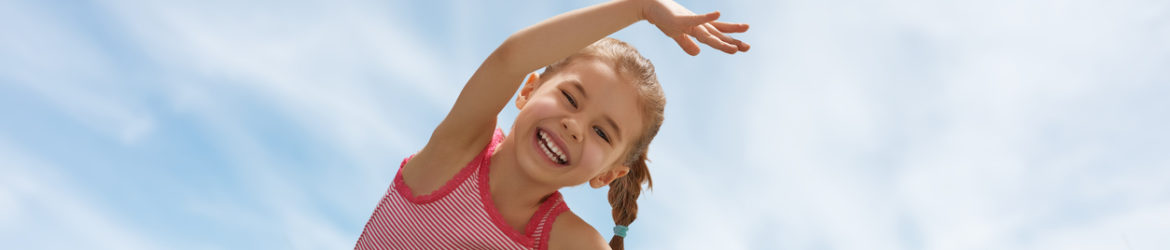 child practicing yoga on the grass outdoors